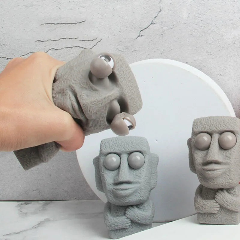 Stone man releases stress toy slowly rebounds soft Moai statue squeeze eyes interested expression relaxes stress children's gift